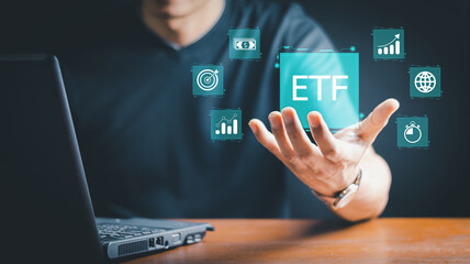 ETF, Exchange traded fund concept. Business stock market finance index fund. Businessman using smartphone and laptop with ETF icons on virtual screen