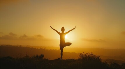 A silhouette shot of a woman practicing yoga on a hill at sunrise, with her arms outstretched towards the sun