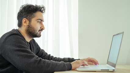 Bearded business man using laptop in office.