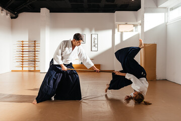 Aikido Practitioner Demonstrates Jo Staff Technique in Traditional Dojo Setting
