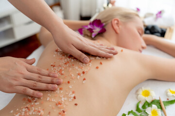 Closeup woman customer having exfoliation treatment in luxury spa salon with warmth candle light...