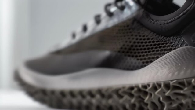 Closeup of a sneaker with a sole made from recycled rubber and a upper made from recycled plastic mesh. Despite being made from recycled materials the shoe has a sleek and modern design. .