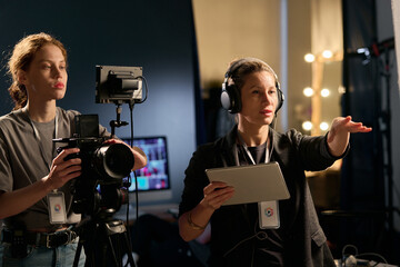 Waist up portrait of female director giving instructions on set during film production copy space