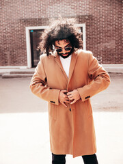 Handsome hipster model.  Unshaven Arabian man dressed in brown coat clothes. Fashion male with long...