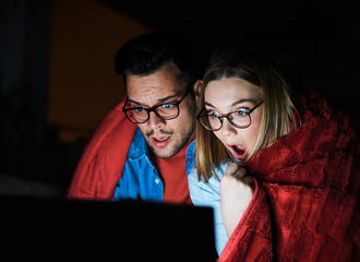 couple movie man watching woman entertainment tv home horror laptop technology computer scared...