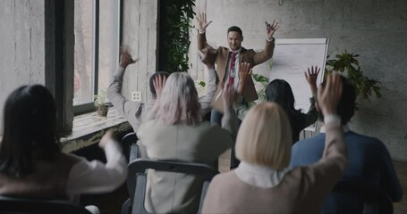 Inspired coach giving course on personal development speaking to group of people in modern office. Coaching and psychology concept.