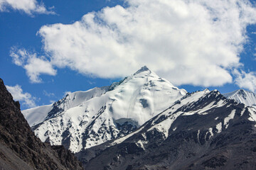 A stunning view of Snow covered mountains and clouds near Khunjerab Pass, Hunza Nagar