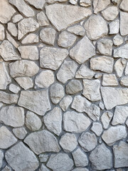 An old stone wall. The texture of old stone. Stone background. Vertical image.