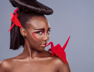 Portrait, cosmetics and black woman with origami for beauty in studio isolated on gray background....