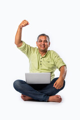 Indian asian mid age man using laptop against white background
