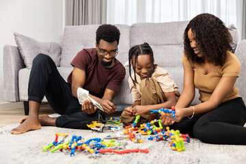Fototapeta premium Family Bonding Over Board Games: Happy African Family Playing Together, Parents And Child Indoor Activity