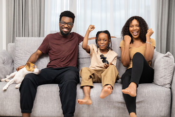 Happy Family Enjoying Video Game Time Together With Their Dog In Living Room