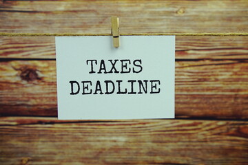Taxes Deadline text on paper card hanging on the wall with Clothespins