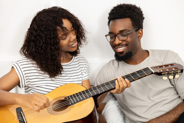 Happy couple Playing Guitar Together At Home, Casual Leisure, Music Hobby, Smiling, African...