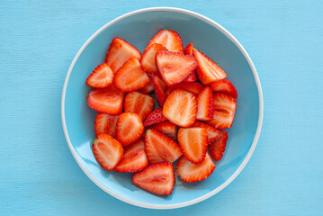 Fresh strawberries on blue ceramic plate.