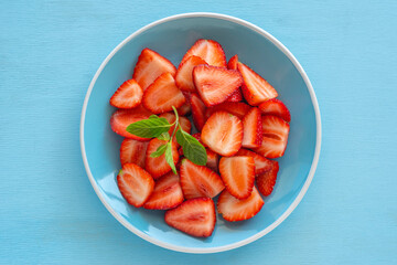 Fresh strawberries on blue ceramic plate..
