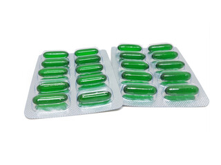 Vitamin E softgel Green capsules in blister pack on white background