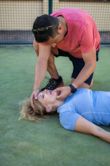 Man Giving First Aid for Choking on Sports Field