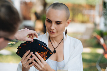A bald woman tarot reader has a session with a client
