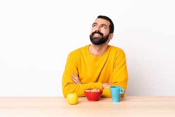 Caucasian man having breakfast in a table thinking an idea while looking up.