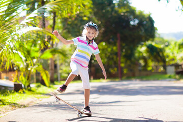 Kid with skateboard. Child riding skate board.