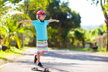 Kid with skateboard. Child riding skate board.