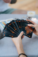 A woman is holding a tarot card deck