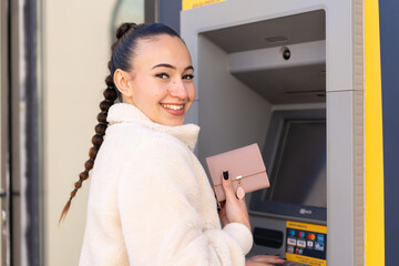 Young moroccan girl  at outdoors using an ATM