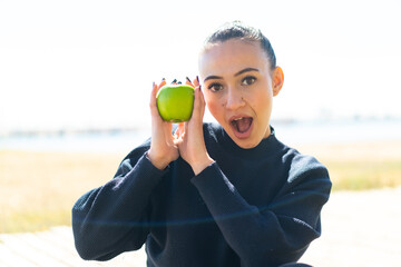 Young moroccan girl  at outdoors holding an apple