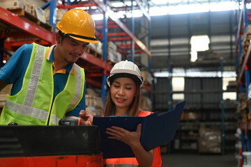 A forklift truck operator talking to a manager or supervisor in a logistic warehouse, Distribution...