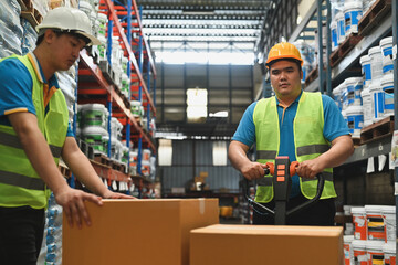 Distribution warehouse workers moving boxes on a hand truck loaded in Warehouse industrial stock...