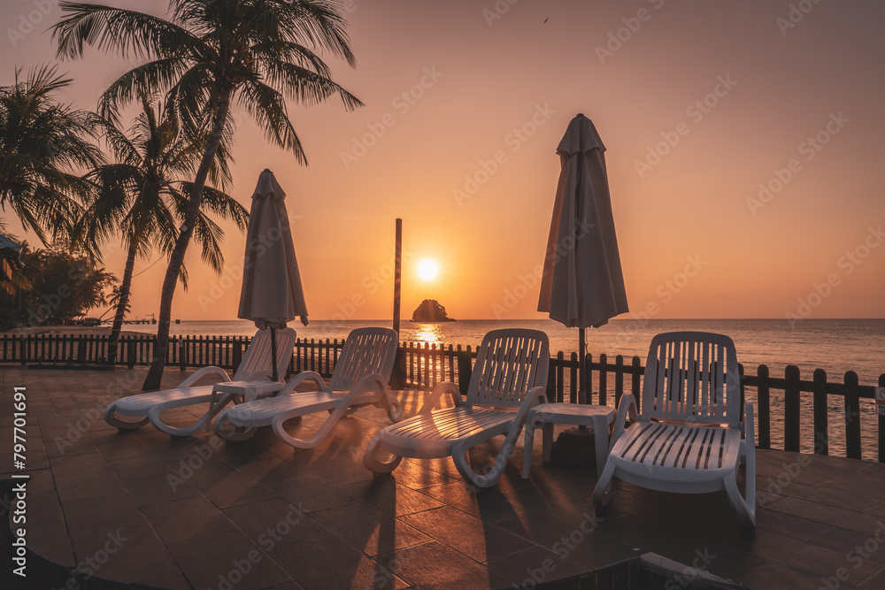 Poster Tropical beach setting with lounge chairs, umbrella, and palm trees