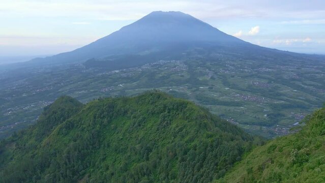 Aerial view of beautiful natural landscape. Slope of Andong Mountain with Merbabu mountain on the background.
