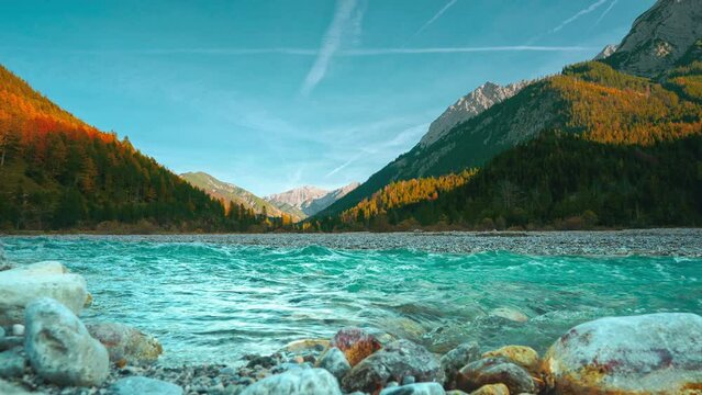 Austrian alps mountain river. Cinemagraph loop. Clear water rushing along colorful autumn trees.