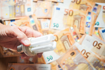 hand holding light bulb energy efficiency saving bills money 