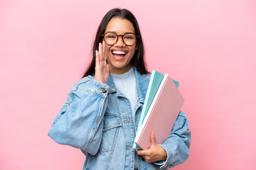 Young student Colombian woman isolated on pink background shouting with mouth wide open