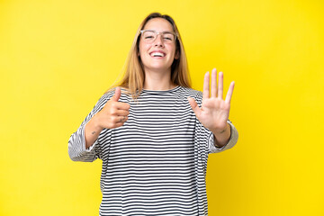 Young caucasian woman isolated on yellow background counting six with fingers