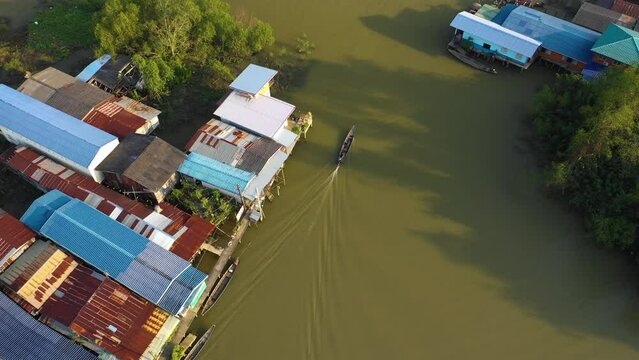 Aerial view following a traditional fishing boat in sunny Surat Thani, Thailand