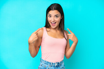 Young caucasian woman isolated on blue background giving a thumbs up gesture