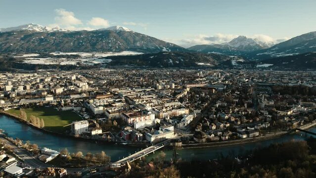 Aerial drone shot of city of Innsbruck, Tyrol, Austria. Cityscape view of houses, town, river and snow covered mountains in distance