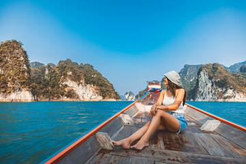 Traveler asian woman relax and travel on Thai longtail boat in Ratchaprapha Dam at Khao Sok National Park Surat Thani Thailand - 797713637