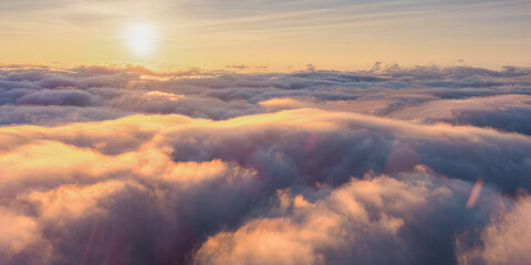 As the sun sets, its sunlight is shining through the clouds in the afterglow of dusk, creating a...