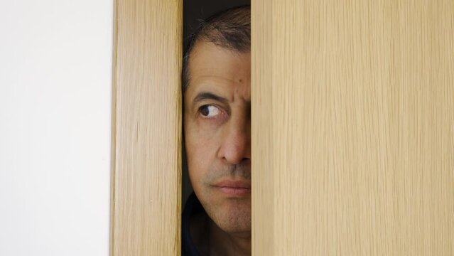 Man spying and entering through the door as concept of nosy man