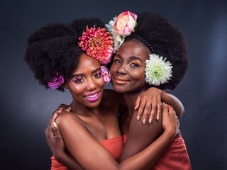 Black women, portrait and flower afro hair as friends in studio on grey background, eco friendly or...