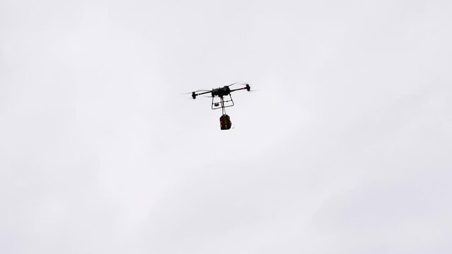 Industrial delivery drone transport heavy medical emergency bag in bright sky