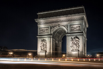 Long exposure image of the arc de triomphe at night, wide angle, showing light trails around the...
