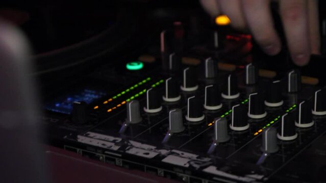 handheld shot of dj playing on a mixer