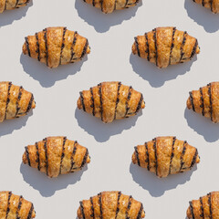 Seamless pattern with chocolate croissant on white background.