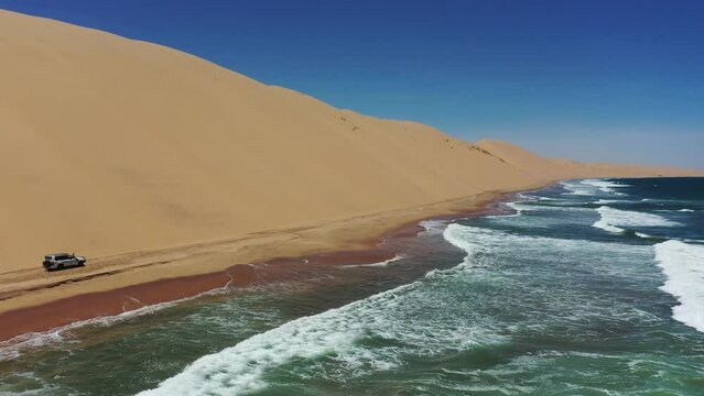 Drone footage of a car drive of a sandy road in Sandwich Harbour Historic, Walvis Bay city, Namibia