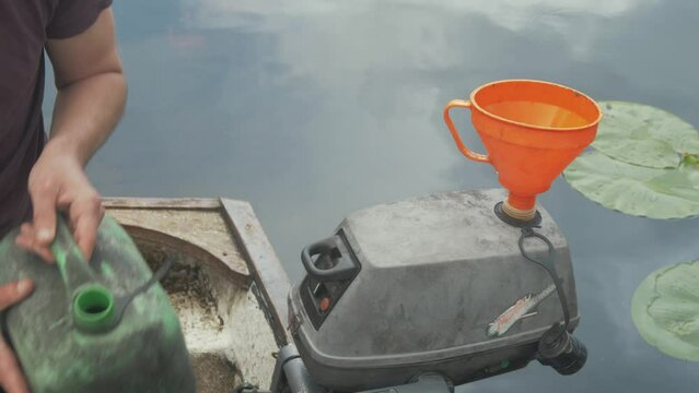 Filling up a two-stroke outboard engine with petrol